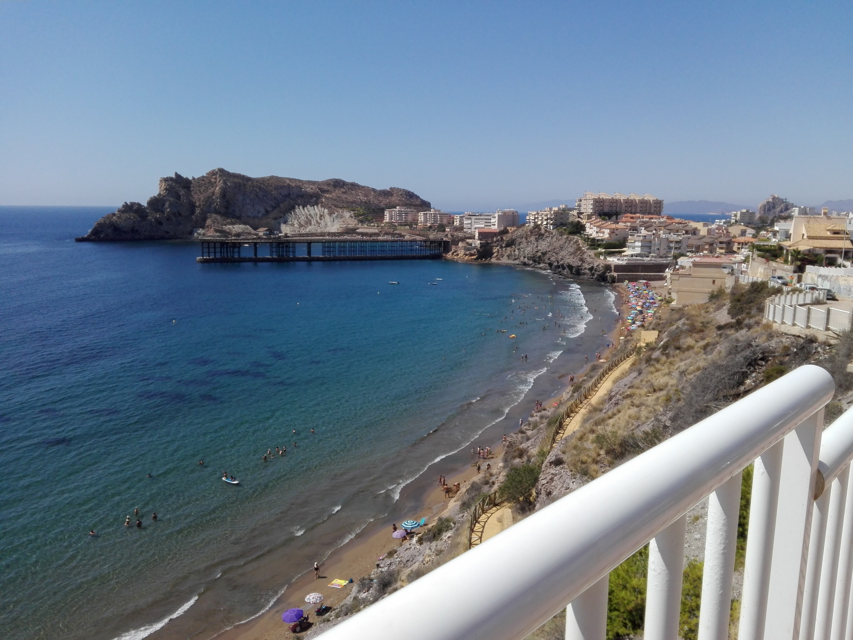 Cala de arena de la Playa del Hornillo en Águilas, Murcia, con el Cargadero al fondo