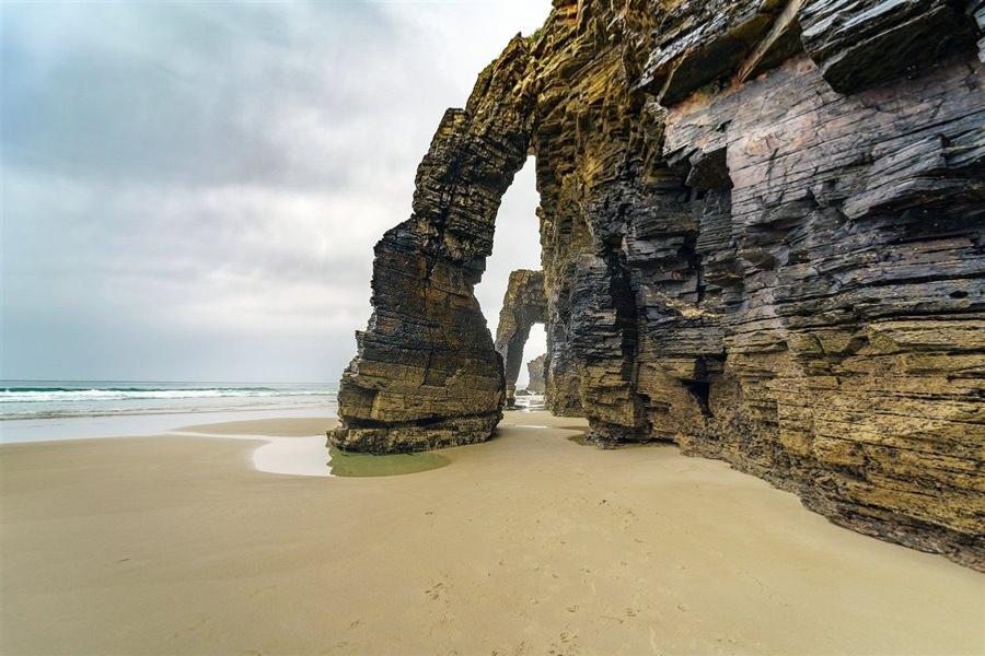 Conjunto de arcos y arenal con marea baja