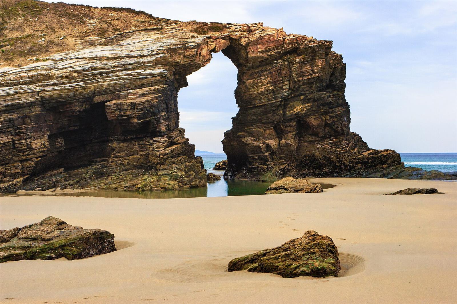 Arco natural de As Catedrais sobre el arenal, con marea baja