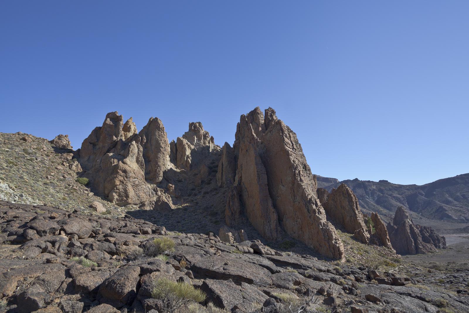 Paisaje de Las Cañadas con las formaciones rocosas y visitantes al fondo, a escala