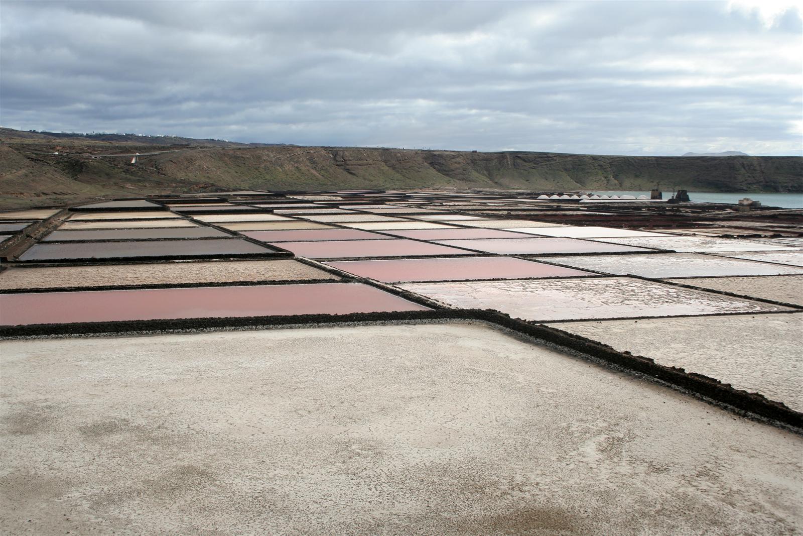 Vista del mirador de las Salinas de Janubio con la barra de arena volcánica negra y el Atlántico, Lanzarote