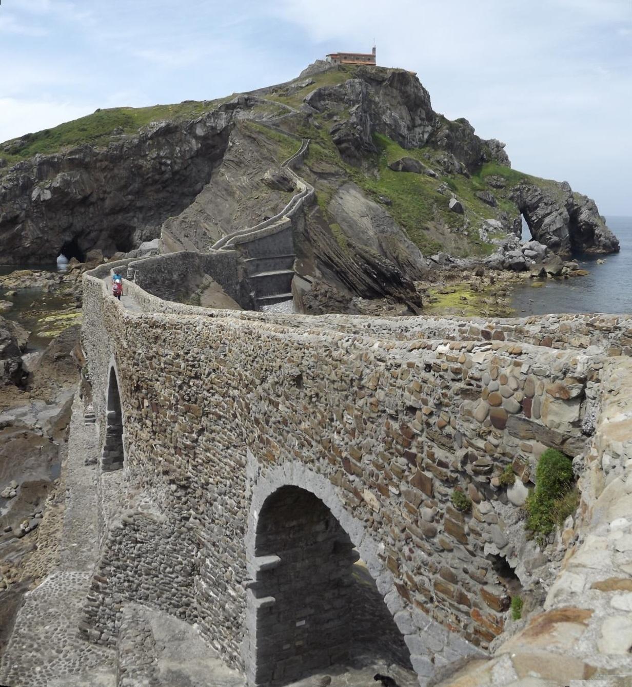 Panorámica del puente de piedra, los arcos, la escalinata y la ermita de Gaztelugatxe