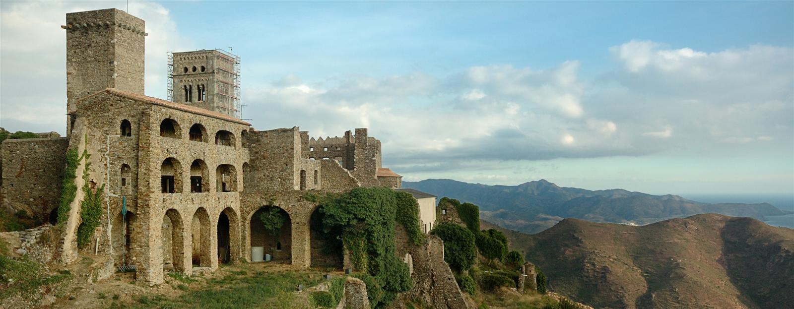Monasterio de Sant Pere de Rodes al atardecer con las montañas y el mar al fondo