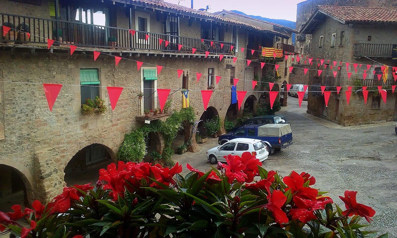 Plaça Major porticada de Santa Pau con soportales de piedra, balcones y fachadas medievales de La Garrotxa, Girona