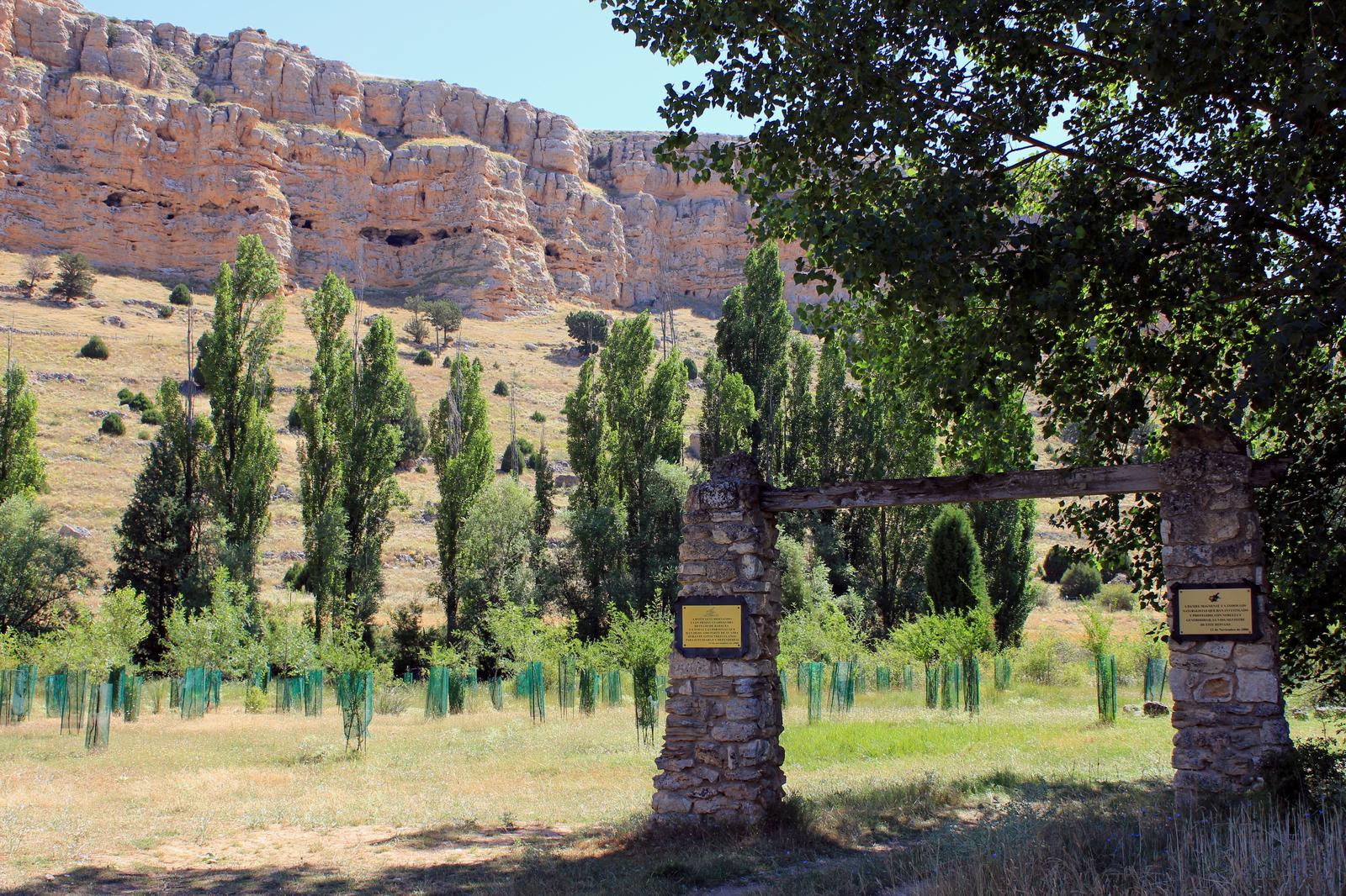 Monumento conmemorativo junto al sendero, con Peña Portillo al fondo