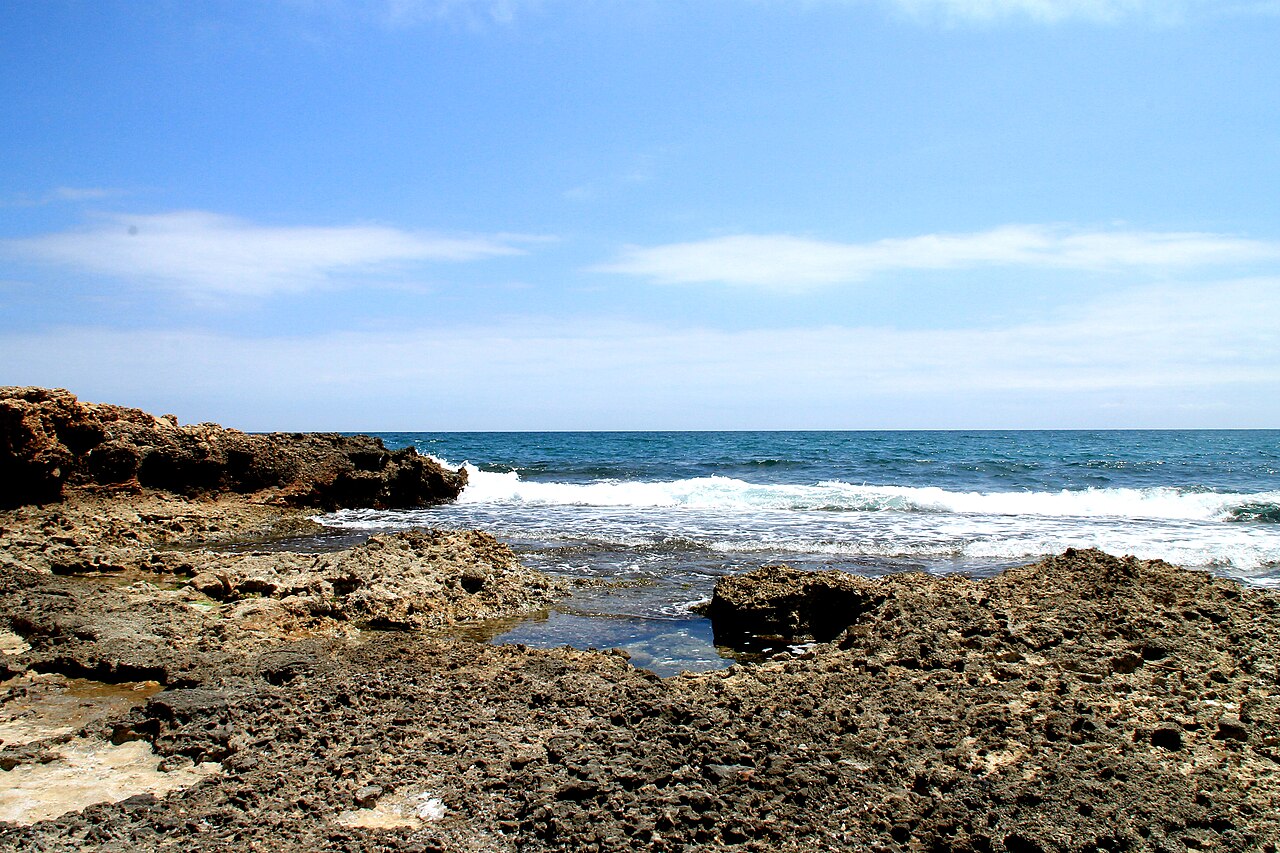 Agua del Mediterráneo rompiendo sobre las rocas en la costa de la Sierra de Irta