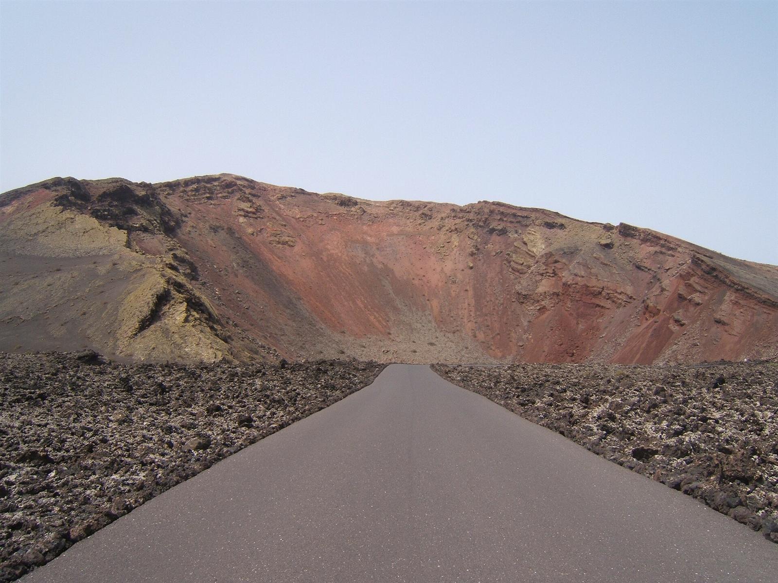 La carretera de acceso al Islote de Hilario entre paredes volcánicas de colores
