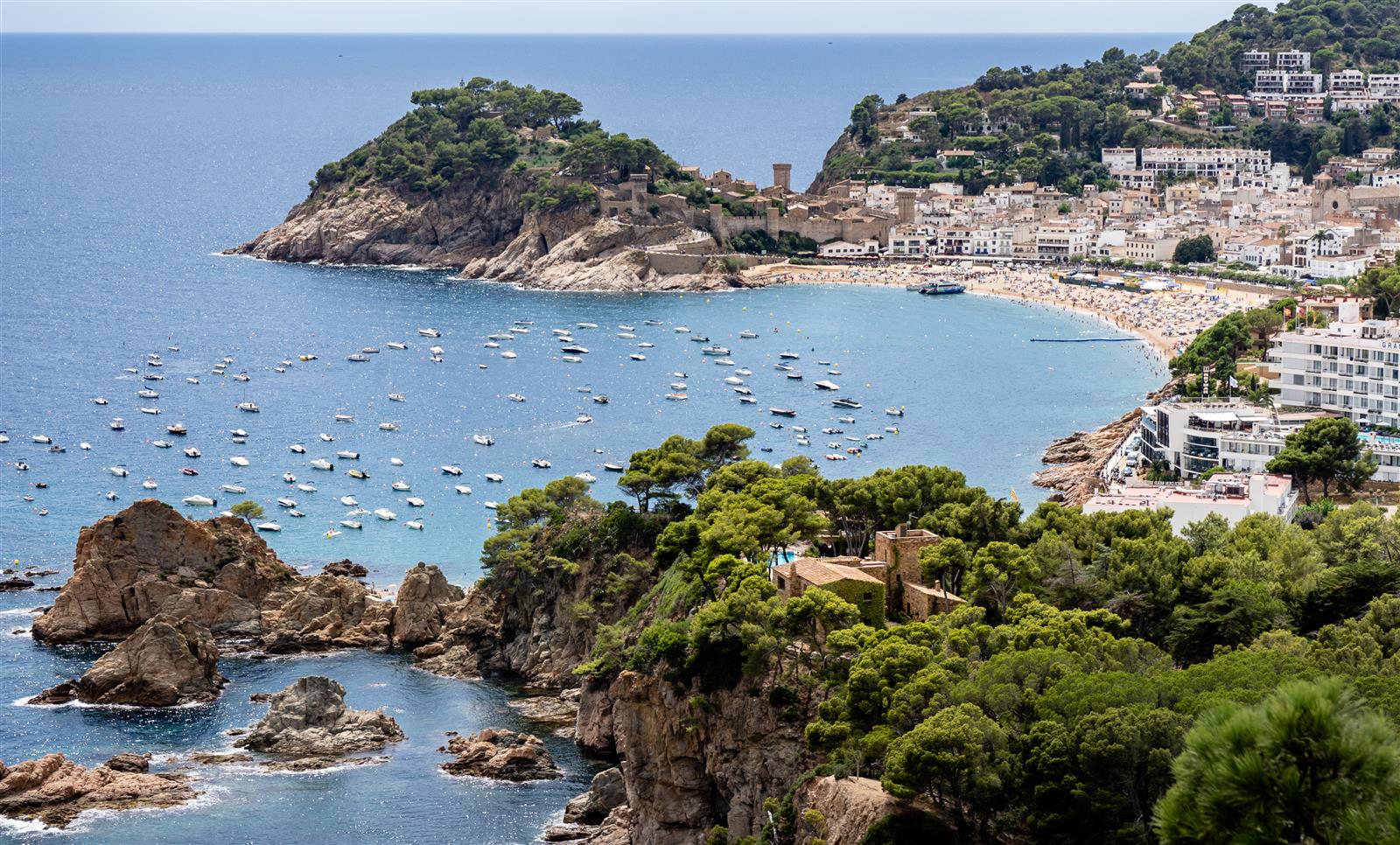Vista aérea de la Vila Vella de Tossa de Mar con sus torres medievales, la bahía azul y la Gran Platja, Costa Brava, Girona