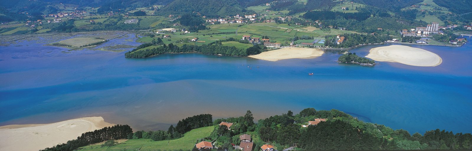 Vista aérea panorámica de la Reserva de la Biosfera de Urdaibai en Bizkaia, País Vasco: el estuario del río Oka con sus marismas, la ría y el pueblo de Mundaka al fondo
